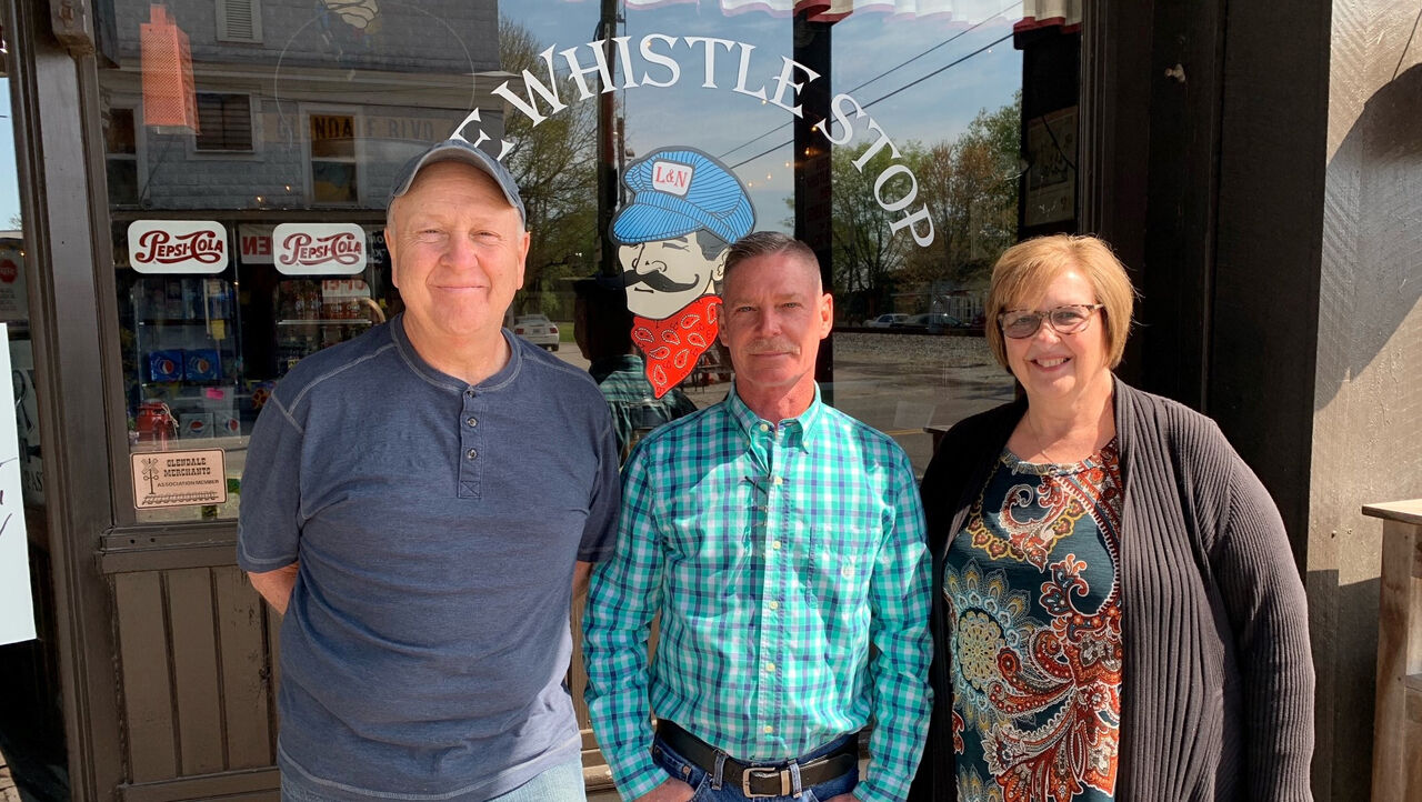 Mike and Lynn Cummins (left and right), previous Whistle Stop owners, with Mike Frantz (center), one of the new co-owners